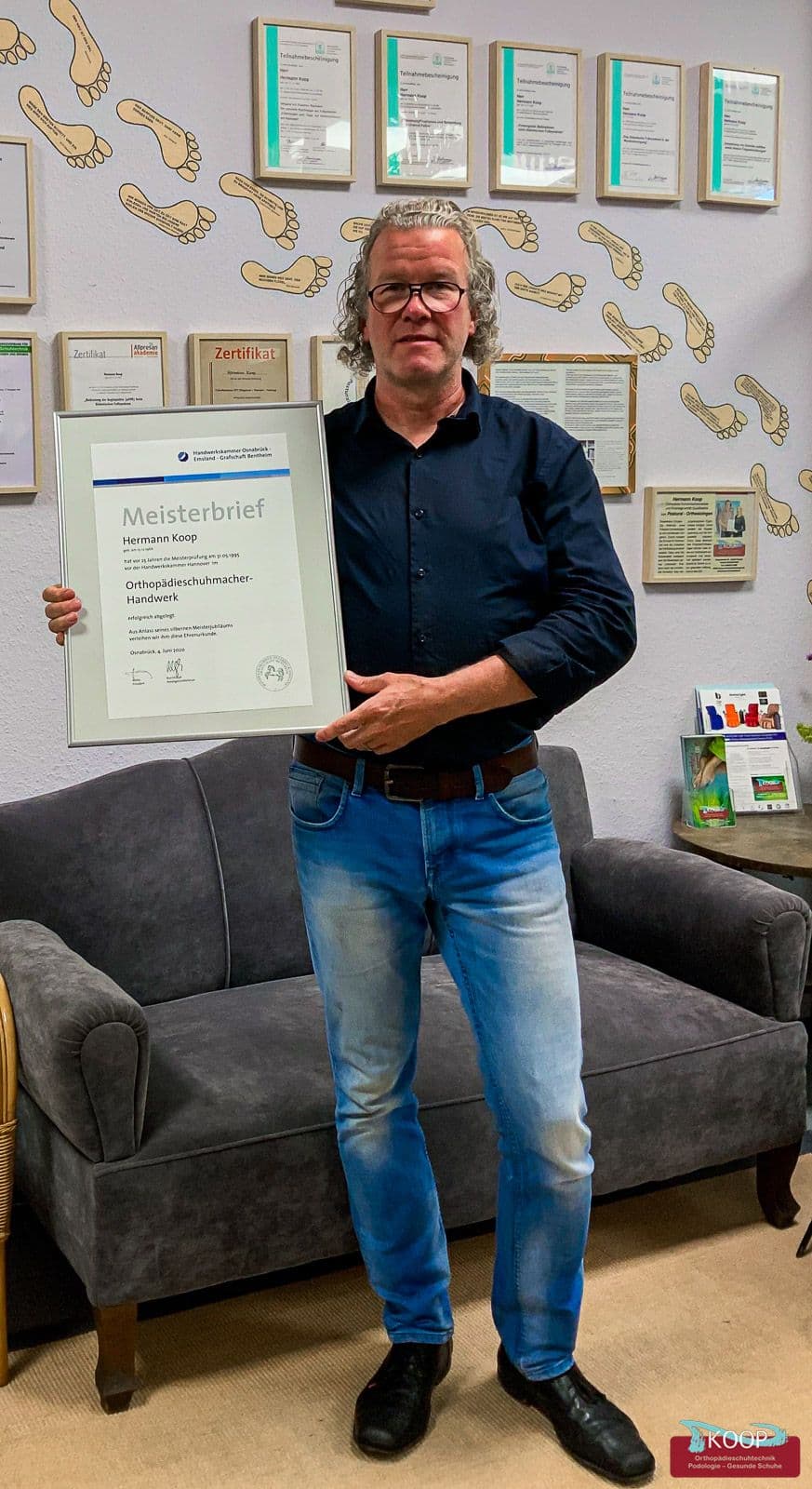 Hermann Koop hält seinen Meisterbrief zum 25-jährigen Jubiläum im Orthopädieschuhmacher-Handwerk in den Händen.
